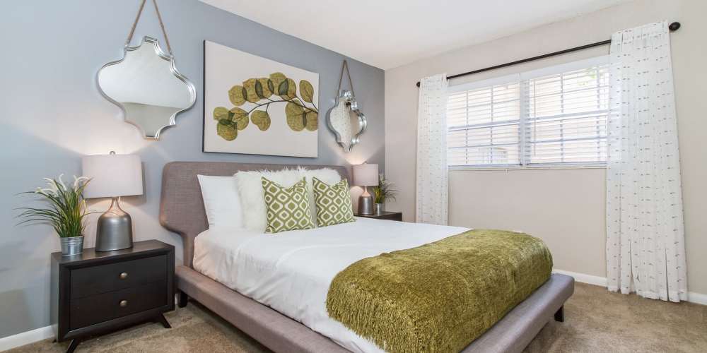 Carpeted apartment bedroom with queen-size bed and large window at Central Place at Winter Park in Winter Park, Florida