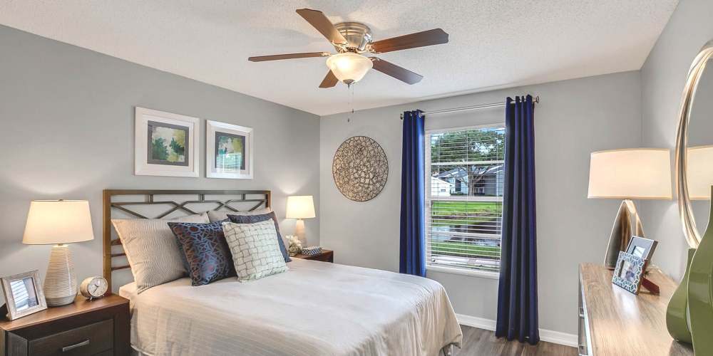 Comfortable apartment bedroom with ceiling fan and large window at Lakeside Central Apartments in Brandon, Florida