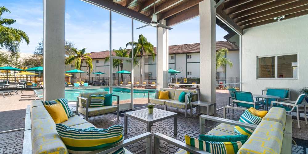 Comfortable covered seating by the pool at Nova Central Apartments in Davie, Florida