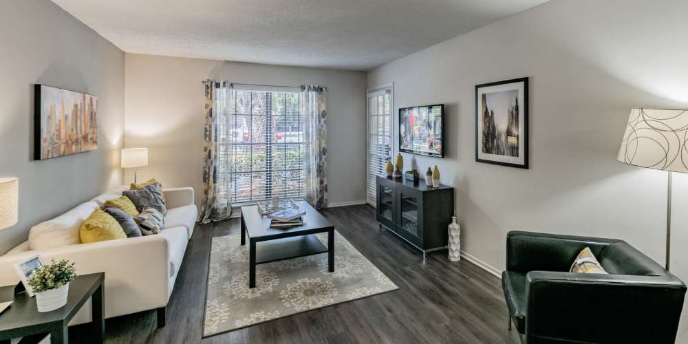Spacious furnished apartment living room with hardwood floors at Legend Oaks in Tampa, Florida
