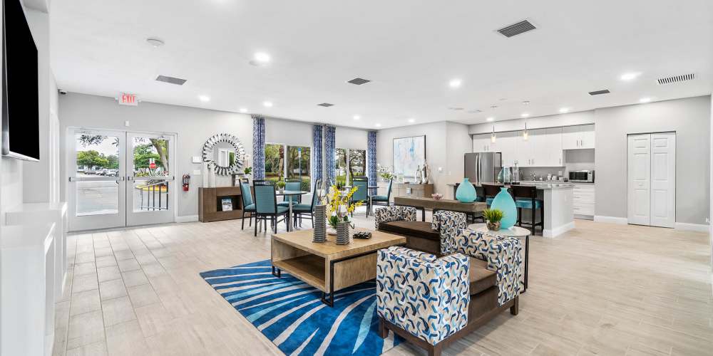 Community clubhouse with couch and dining area at Boynton Place Apartments in Boynton Beach, Florida