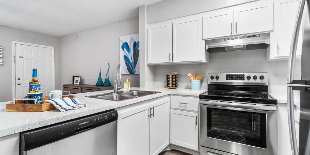 Modern apartment kitchen with stainless steel appliances at Boynton Place Apartments in Boynton Beach, Florida