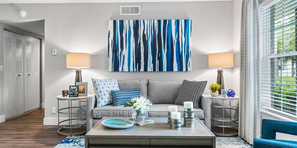 Furnished apartment living room with sofa, coffee table, and matching end tables at Boynton Place Apartments in Boynton Beach, Florida