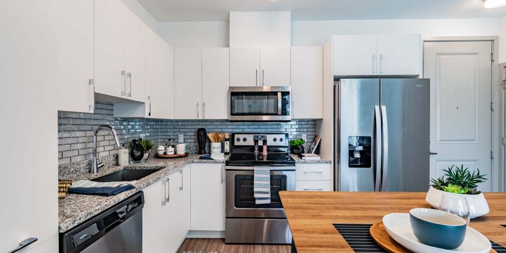 Apartment kitchen with white cabinets and stainless steel appliances at Vue on Lake Monroe in Sanford, Florida