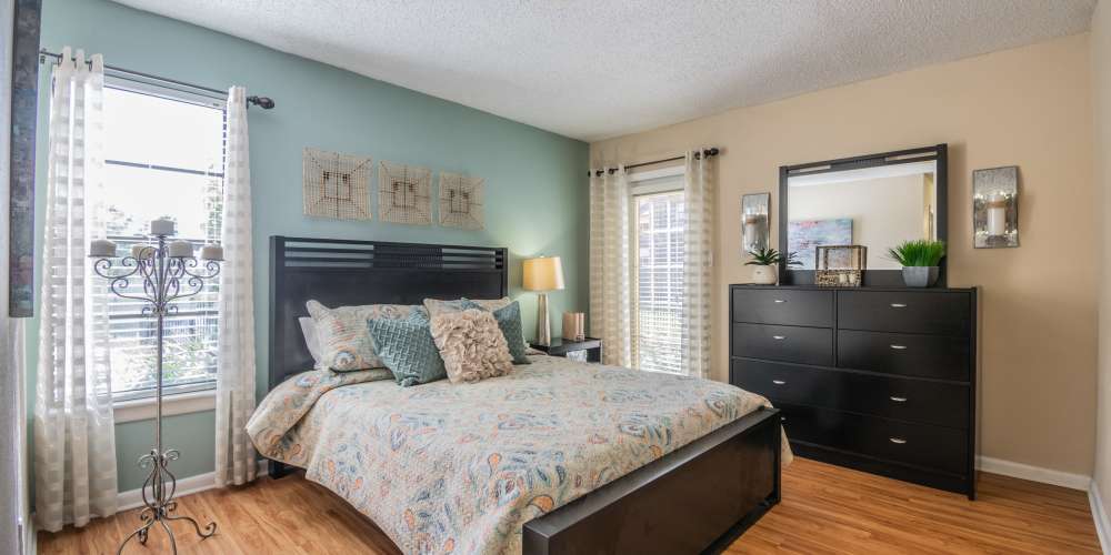 Apartment bedroom with 2 windows and hardwood floors at Waterstone At Carrollwood in Tampa, Florida