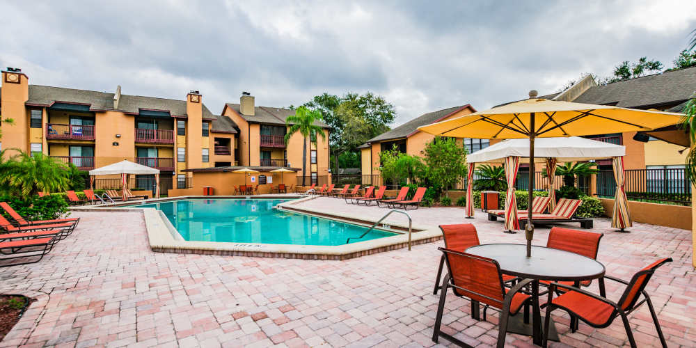 Luxury community pool with patio seating at Waterstone At Carrollwood in Tampa, Florida