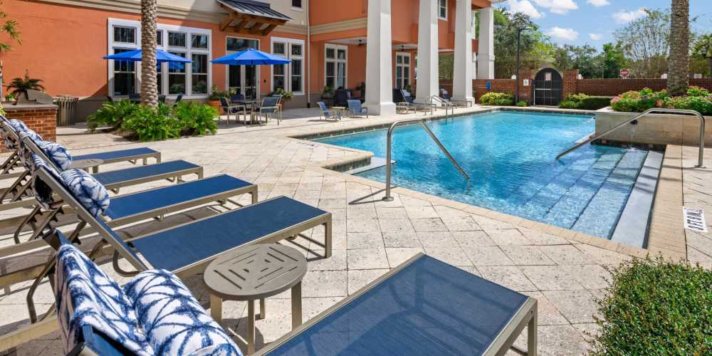 Community inground pool with lounge chairs at Station House at Lake Mary in Lake Mary, Florida