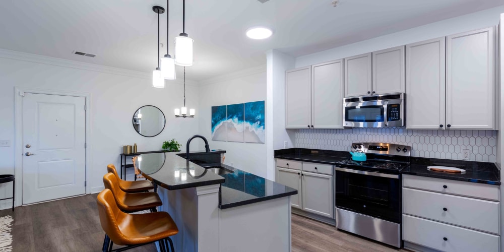 An apartment kitchen with a tile backsplash at Spring Water Apartments in Virginia Beach, Virginia