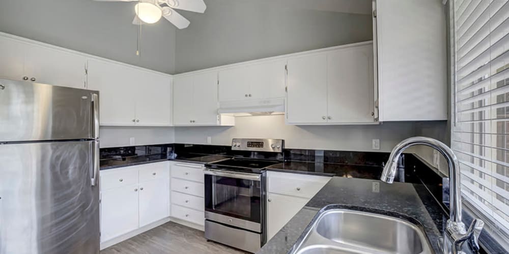 Kitchen with appliances and white cabinetry at Espana East in Sacramento, California