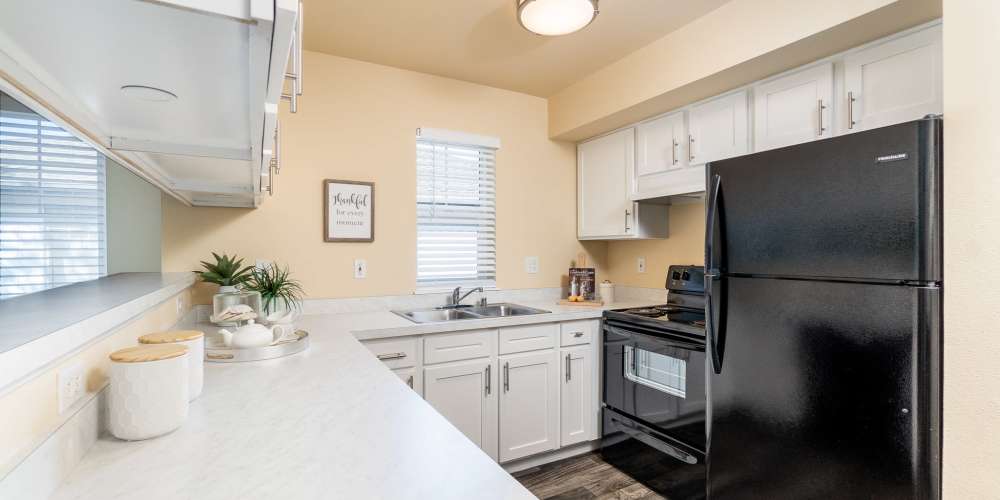 Apartment kitchen with white cabinets and black appliances at Barkley Apartments in Bellingham, Washington