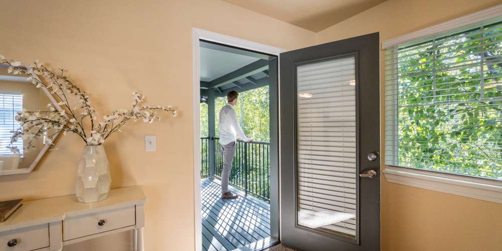 Doorway leading to a balcony with a man looking out at Barkley Apartments in Bellingham, Washington