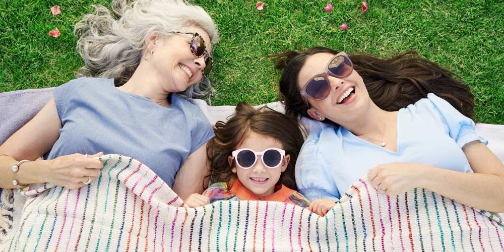 Family lying down on a mat on the grass at BB Living Wellen Park in Venice, Florida