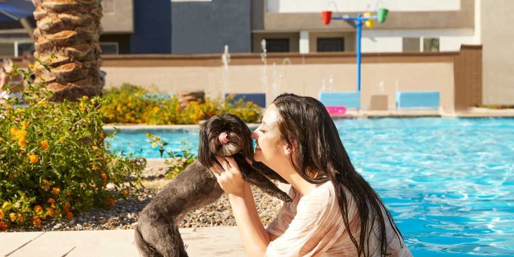 Resident and her dog in the pool area at BB Living Wellen Park in Venice, Florida