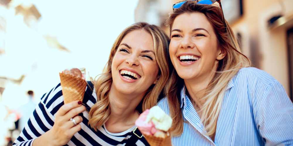 Happy friends eating ice cream near 353 Main Street Family Apartments in Redwood City, California