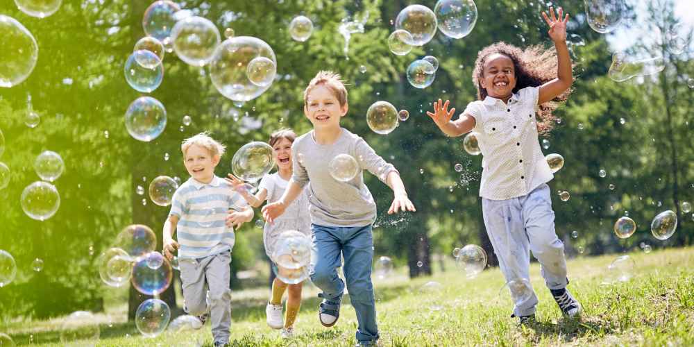 Happy kids playing at park near 353 Main Street Family Apartments in Redwood City, California