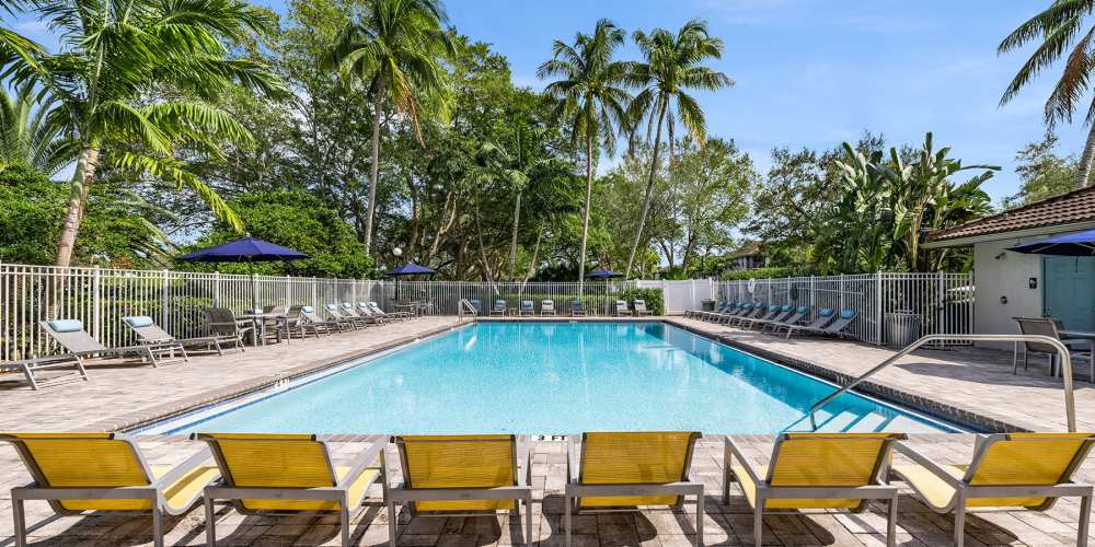 Resort-style pool with lounge chairs at Boynton Place Apartments in Boynton Beach, Florida