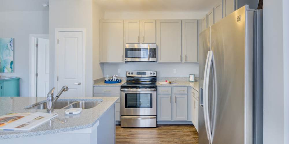 Stainless-steel appliances in an apartment kitchen at Reserve at River Place in Youngsville, Louisiana