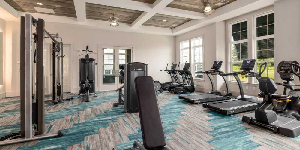 State-of-the-art fitness center with treadmills, weight machines, and ceiling fans at Hudson Carolina Forest in Myrtle Beach, South Carolina