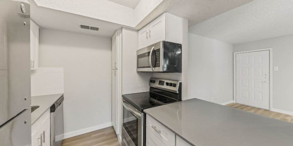 Kitchen with black appliances at Tides at Highland Meadows in Dallas, Texas