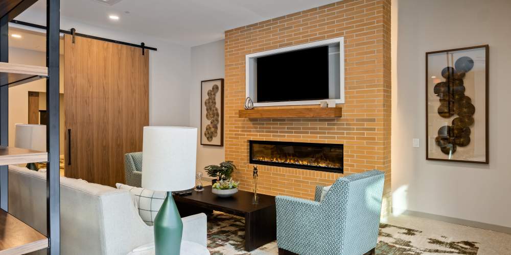 A stylish living room showcasing a fireplace alongside a television  at The Barclay in Charlottesville, Virginia