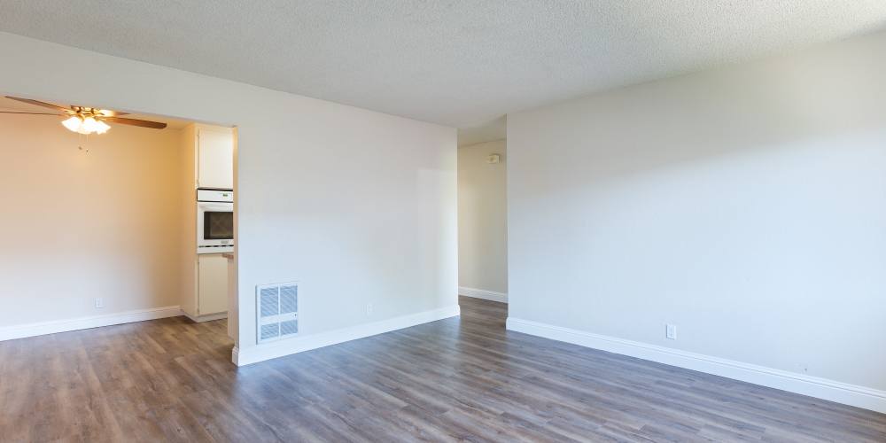 Spacious apartment with wood-style flooring at Marina Plaza Apartments in San Leandro, California