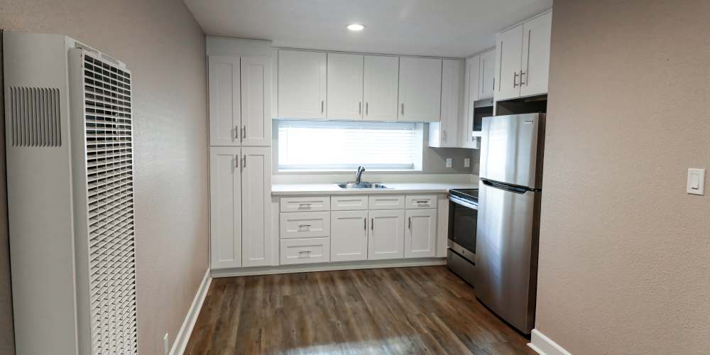 Kitchen with white appliances at Briarwood Apartments in Livermore, California