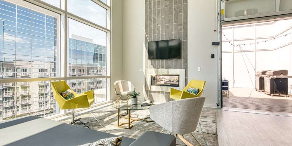 Clubhouse with a fireplace and city views in a Drucker + Falk multifamily property
