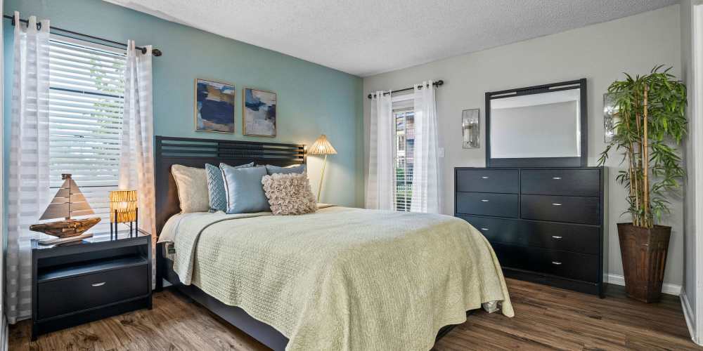 Apartment bedroom with 2 windows and hardwood floors at Waterstone At Carrollwood in Tampa, Florida