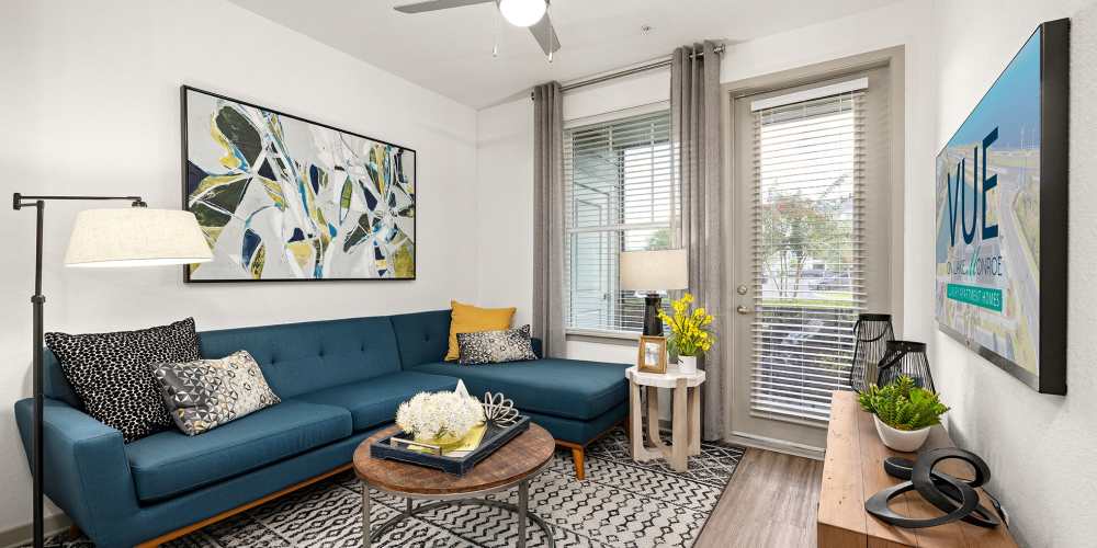 Apartment living room with hardwood floors and sectional sofa at Vue on Lake Monroe in Sanford, Florida