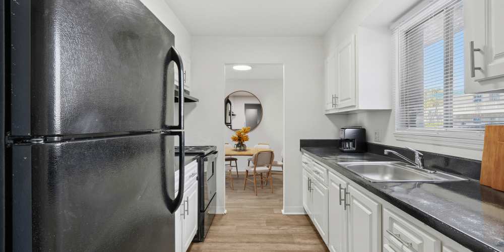 Apartment kitchen with black appliances and white cupboards at Costa Del Lago in Lake Worth, Florida