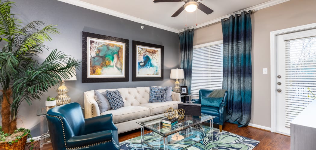 Wide-angle view of lavish living room in model apartment at The Abbey at Grande Oaks