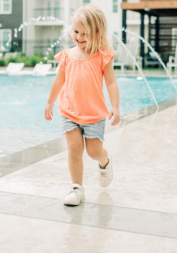 Kid walking near swimming pool at The Flats at Ransley in Pensacola, Florida