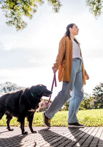 Resident walking with a dog at The Flats at Veranda Ridge in Texas City, Texas