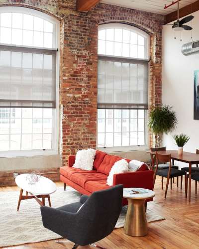 Spacious living room with beautiful couch and big windows at Revolution Mill in Greensboro, North Carolina