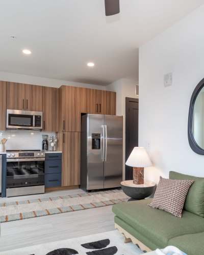 Furnished living room and kitchen. The kitchen has light wood cabinets at The Row in Raleigh,North Carolina