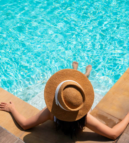 Resident in sun hat relaxing at the pool at Montage at Marquis Hills in Williamsburg, Virginia