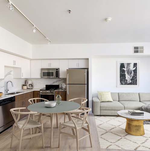Kitchen and living room with wood-style flooring at 1801L Apartments in Sacramento, California