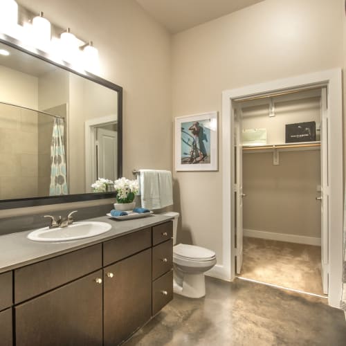 Granite countertop and a large vanity mirror in a model home's bathroom at Olympus at Ross in Dallas, Texas