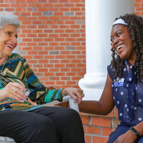 Resident and caregiver outside at The Crossings at Ironbridge in Chester, Virginia