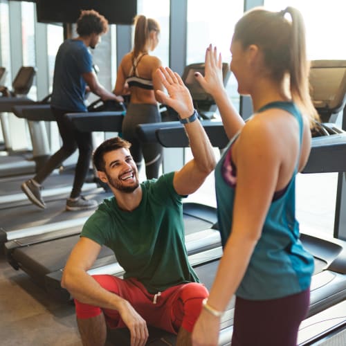 Residents high-fiving each other during a break from their workout in the fitness center at The Preserve at Greison Trail in Newnan, Georgia