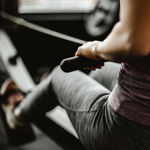 Resident working out on the rowing machine in the fitness center at The Coast of Naples Florida in Naples, Florida
