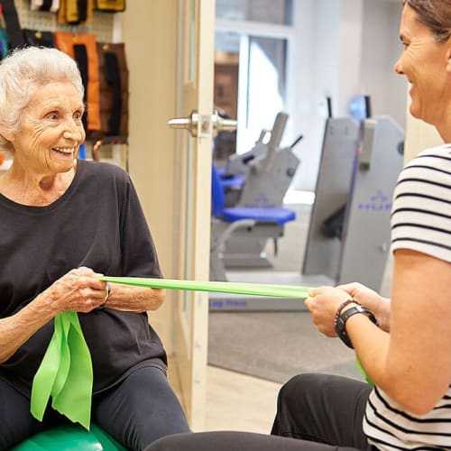 Resident exercising with personal trainer at Celebration Village Acworth in Acworth, Georgia