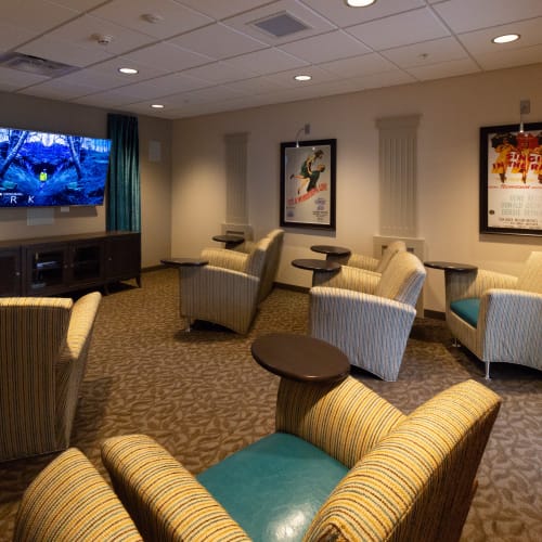 Cozy chairs inside movie theater with attachable table at First & Main of Commerce Township in Commerce Township, Michigan