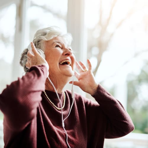 Gleeful resident listening to music at Oxford Springs Tulsa Memory Care in Tulsa, Oklahoma