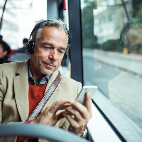 Resident using his phone on the bus at Forest Cove in Doraville, Georgia
