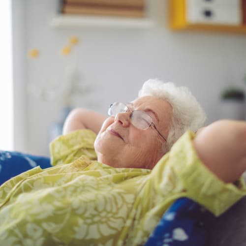 Resident relaxing on her couch at Saddlebrook Oxford Memory Care in Frisco, Texas