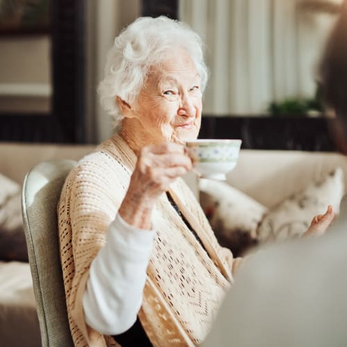 Resident drinking tea at Saddlebrook Oxford Memory Care in Frisco, Texas