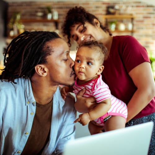 Resident kissing his baby on the cheek at Mandalane Apartments in Wheeling, Illinois