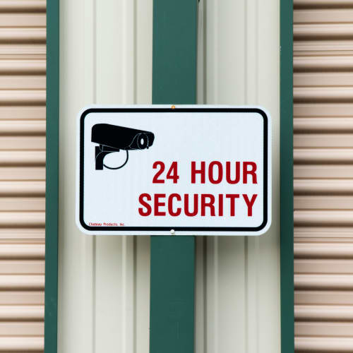 A sign for 24 hour security at Red Dot Storage in Evansville, Indiana