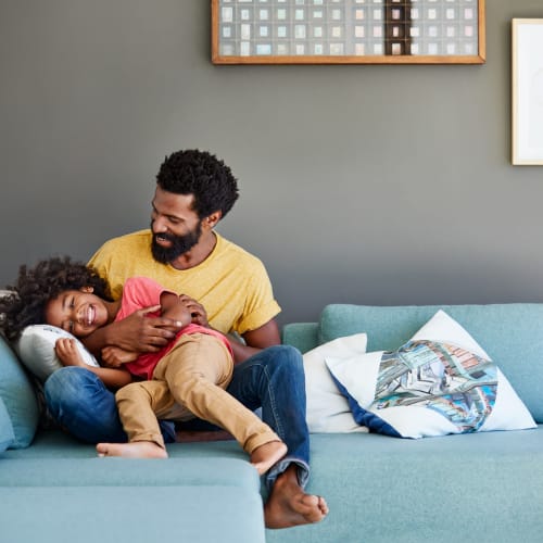 Resident and his daughter sitting on a couch at Hawkins Meadow in Amherst, Massachusetts